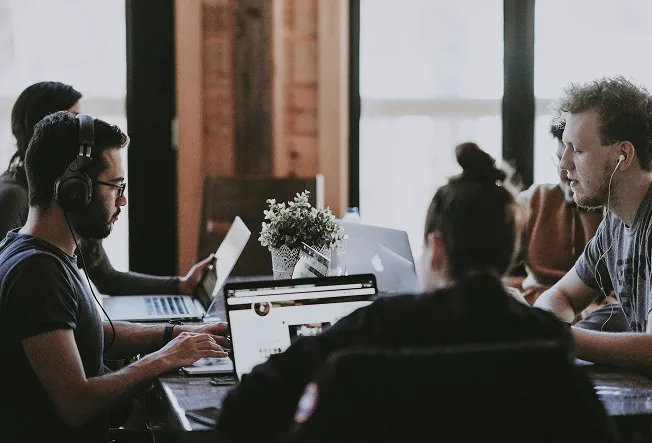 A marketing team working on their laptops next to each other
